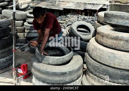 Dhaka, Bangladesch. Oktober 2021. Arbeiter aus Bangladesch schnitten am 14. Oktober 2021 in Dhaka alte Reifen, die recycelt werden sollen. ( Credit: SIPA USA/Alamy Live News Stockfoto