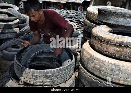 Dhaka, Bangladesch. Oktober 2021. Arbeiter aus Bangladesch schnitten am 14. Oktober 2021 in Dhaka alte Reifen, die recycelt werden sollen. ( Credit: SIPA USA/Alamy Live News Stockfoto