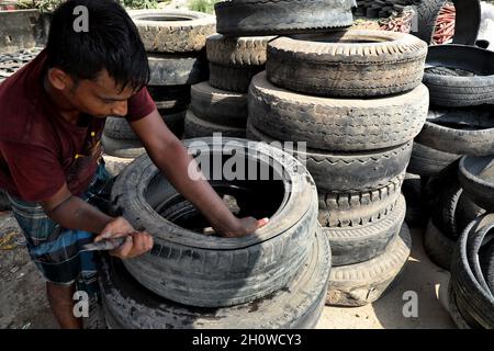 Dhaka, Bangladesch. Oktober 2021. Arbeiter aus Bangladesch schnitten am 14. Oktober 2021 in Dhaka alte Reifen, die recycelt werden sollen. ( Credit: SIPA USA/Alamy Live News Stockfoto