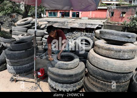 Dhaka, Bangladesch. Oktober 2021. Arbeiter aus Bangladesch schnitten am 14. Oktober 2021 in Dhaka alte Reifen, die recycelt werden sollen. ( Credit: SIPA USA/Alamy Live News Stockfoto