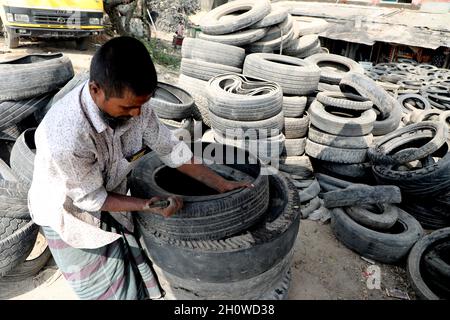 Dhaka, Bangladesch. Oktober 2021. Arbeiter aus Bangladesch schnitten am 14. Oktober 2021 in Dhaka alte Reifen, die recycelt werden sollen. ( Credit: SIPA USA/Alamy Live News Stockfoto