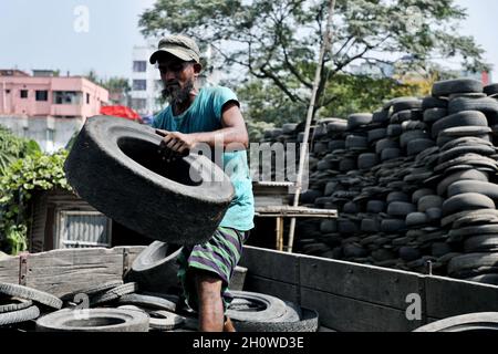 Dhaka, Bangladesch. Oktober 2021. Am 14. Oktober 2021 laden Arbeiter Teile gebrauchter Reifen zum Recycling auf einen LKW in Dhaka, Bangladesch. ( Credit: SIPA USA/Alamy Live News Stockfoto