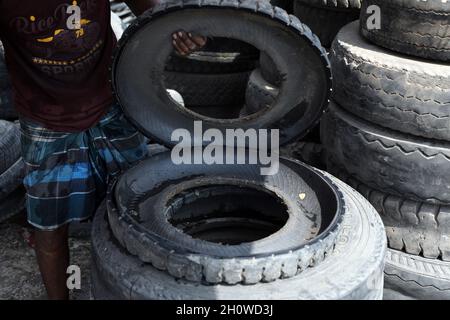 Dhaka, Bangladesch. Oktober 2021. Arbeiter aus Bangladesch schnitten am 14. Oktober 2021 in Dhaka alte Reifen, die recycelt werden sollen. ( Credit: SIPA USA/Alamy Live News Stockfoto