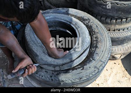 Dhaka, Bangladesch. Oktober 2021. Arbeiter aus Bangladesch schnitten am 14. Oktober 2021 in Dhaka alte Reifen, die recycelt werden sollen. ( Credit: SIPA USA/Alamy Live News Stockfoto