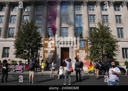 Washington, Usa. Oktober 2021. Demonstranten, die von der Auslöschung der Klimaaktivisten-Gruppe bedroht sind, erklimmern die Außenfassade des Gebäudes der Handelskammer und geben farbigen Rauch frei, während eines Protestes in Washington, DC, am Donnerstag, dem 14. Oktober 2021. Foto von Sarah Silbiger/UPI Credit: UPI/Alamy Live News Stockfoto