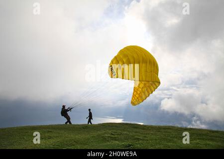 Ein Gleitschirm testet seine Ausrüstung und Windstärke in Puncak Lawang am Rande von Danau Maninjau in der Nähe von Bukittinggi in West Java, Indonesien. Stockfoto