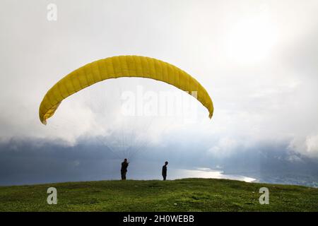 Ein Gleitschirm testet seine Ausrüstung und Windstärke in Puncak Lawang am Rande von Danau Maninjau in der Nähe von Bukittinggi in West Java, Indonesien. Stockfoto