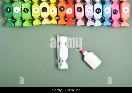 MACHEN SIE ES SELBST. Adventskalender aus farbigem Papier in Form von Süßigkeiten. Schritt-für-Schritt-Anweisungen. Schritt 10. Wir kleben sie zusammen. Stockfoto