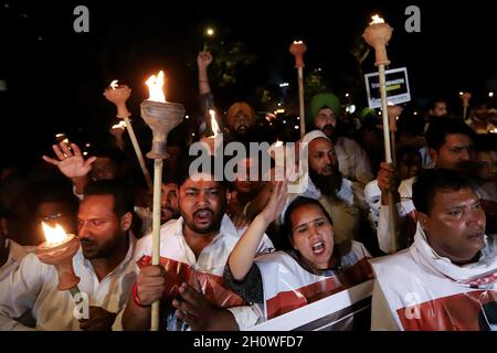 Neu-Delhi, Indien. Oktober 2021. Mitglieder des indischen Jugendkongresses (IYC) halten Fackeln, während sie während eines Protestes Slogans rufen. Der indische Jugendkongress fordert den Rücktritt des Innenministers der Union, Ajay Mishra, nach der Gewalt von Uttar Pradesh in Lakhimpuri Kheri, bei der am 3. Oktober 2021 acht Menschen, darunter vier Bauern, getötet wurden. Kredit: SOPA Images Limited/Alamy Live Nachrichten Stockfoto