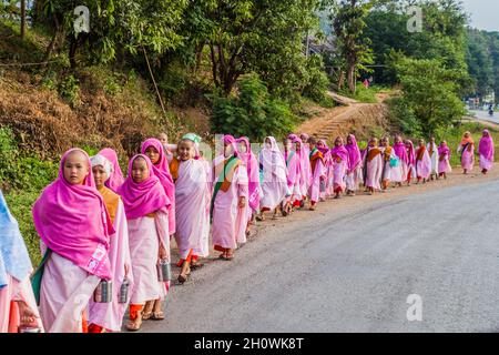 HSIPAW, MYANMAR - 1. DEZEMBER 2016: Junge buddhistische Nonnen gehen in einem Dorf in der Nähe von Hsipaw, Myanmar, zur Almosen Stockfoto