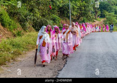 HSIPAW, MYANMAR - 1. DEZEMBER 2016: Junge buddhistische Nonnen gehen in einem Dorf in der Nähe von Hsipaw, Myanmar, zur Almosen Stockfoto