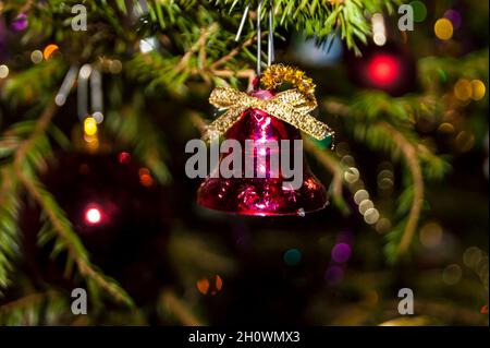 Silvester oder Weihnachten lebhaft elegant dekoriert FichtenNahaufnahme - Weihnachtsspielzeug vor dem Hintergrund von grünen Ästen und Lichtern. Stockfoto