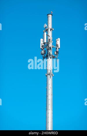 Die Spitze eines Zellturms gegen einen blauen Himmel. Stockfoto