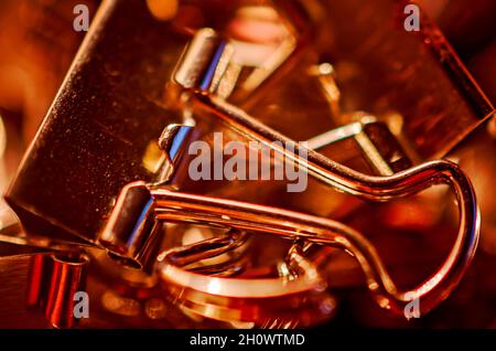 Metallbinderclips, auch bekannt als Klappclips und Bulldog-Clips, sind am 20. Juli 2016 auf einem Schreibtisch in CODEN, Alabama, verstreut. Stockfoto