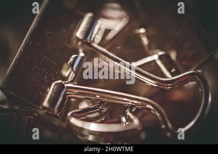 Metallbinderclips, auch bekannt als Klappclips und Bulldog-Clips, sind am 20. Juli 2016 auf einem Schreibtisch in CODEN, Alabama, verstreut. Stockfoto