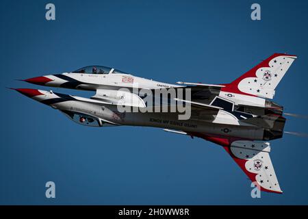 Die Solopiloten der United States Air Force Air Demonstration Squadron „Thunderbirds“ führen den Reflexionspass während der Wings over Houston Airshow in Houston, Texas, am 8. Oktober 2021 durch. Das Lead-Solo fliegt invertiert, während das gegnerische Solo daneben fliegt, was die optische Illusion einer Spiegelung in der Luft erzeugt. (USA Foto der Luftwaffe von Staff Sgt. Andrew D. Sarver) Stockfoto