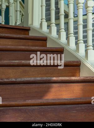 Nahaufnahme des Treppengeländer aus Vintage-Holz. Eine elegante, antike Wendeltreppe aus Holz. Innendesign, selektiver Fokus. Stockfoto