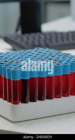 Nahaufnahme von Staubsaugern mit flüssigem Blut im Labor auf dem Schreibtisch. Tablett mit Forschungsflaschen für flüssige dna zur Vorbereitung der wissenschaftlichen Analyse. Ausrüstung für die pharmazeutische Entwicklungsindustrie Stockfoto