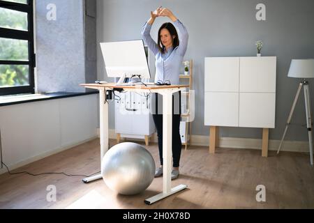 Übung Zum Dehnen Der Mitarbeiter Am Schreibtisch Im Büro Stockfoto