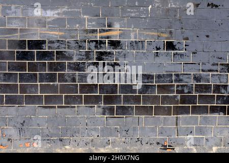 Wand mit alten schwarzen glänzenden Fliesen. Hochwertige Fotos Stockfoto
