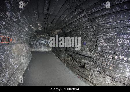 Überreste des unterirdischen Treibstoffdepots der sowjetischen Armee in Rabštejn-Janská, Tschechien. Ein Verbindungsstollen mit Inskriptonen, die von inoffiziellen Besuchern gemacht wurden. Stockfoto