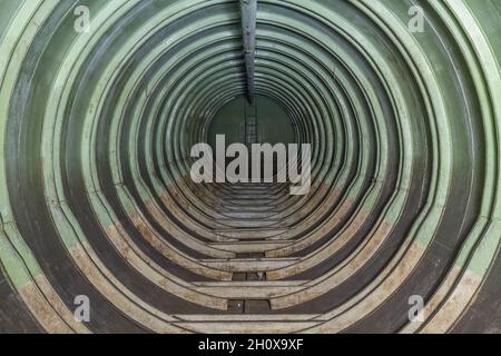 Überreste des unterirdischen Treibstoffdepots der sowjetischen Armee in Rabštejn-Janská, Tschechien. Innenraum eines langen Kraftstofftanks, mit einer Leiter am Ende Stockfoto