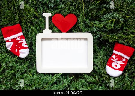 Weihnachtlicher leerer Rahmen und rote Socken auf Tannenzweigen Stockfoto