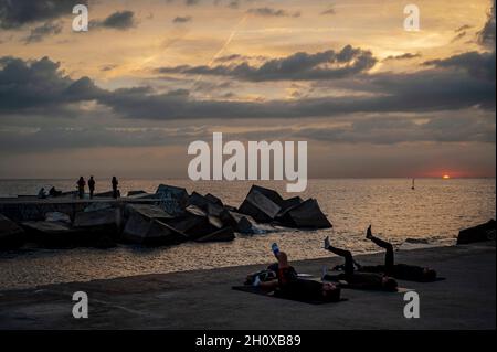 Barcelona, Spanien. Oktober 2021. Barcelona, Spanien. 15. Oktober 2021: In Barcelona üben sich die Menschen auf einem Pier, während die Sonne über dem Mittelmeer aufgeht. Quelle: Jordi Boixareu/Alamy Live News Stockfoto