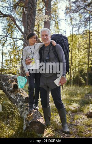 Vater mit im Wald und Blick auf die Kamera Stockfoto
