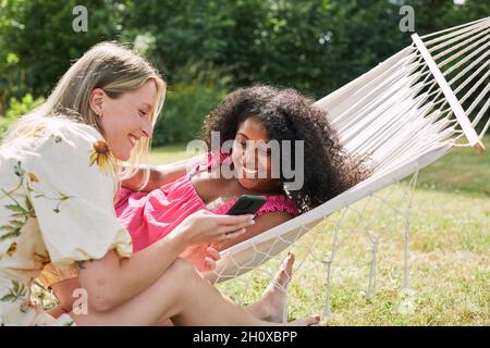 Lächelnde Frauen reden im Garten Stockfoto