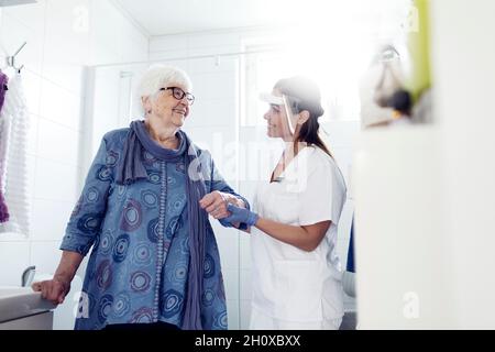 Krankenschwester hilft älteren Frauen im Badezimmer Stockfoto