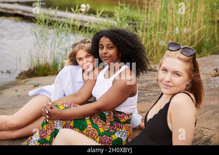 Gruppe von Freunden, die am See ausruhen Stockfoto