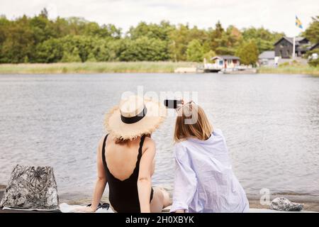 Zwei Freunde, die am See Selfie machen Stockfoto