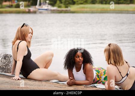 Gruppe von Freunden, die am See ausruhen Stockfoto