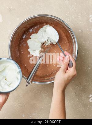 Schokoladenkuchen Teigherstellung Prozess, Hinzufügen von Joghurt zum Teig, Draufsicht Stockfoto