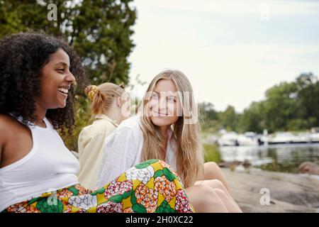 Gruppe von Freunden, die am See ausruhen Stockfoto
