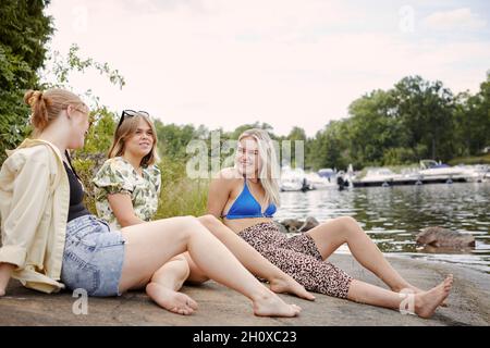 Gruppe von Freunden, die am See ausruhen Stockfoto