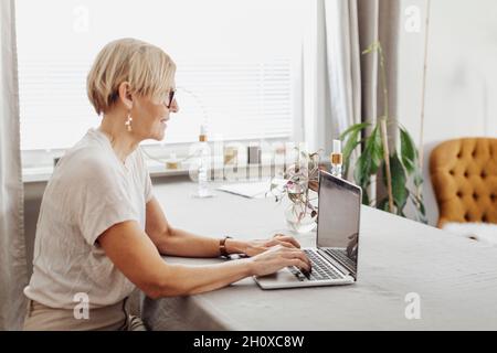 Lächelnde Frau mit Laptop zu Hause Stockfoto
