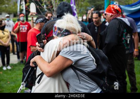 Arlington, Usa. Oktober 2021. Die Demonstranten sahen, wie sie sich während der Demonstration umarmten. Wasserschützer und indigene Aktivisten demonstrierten vor der Wohnung von Jaime Pinkham vom U.S. Army Corps of Engineers und baten ihn um ein Treffen, um über die Verschmutzung zu diskutieren, die das Wasser und die Luft der Gemeinden in den Vereinigten Staaten verwüstet. Kredit: SOPA Images Limited/Alamy Live Nachrichten Stockfoto