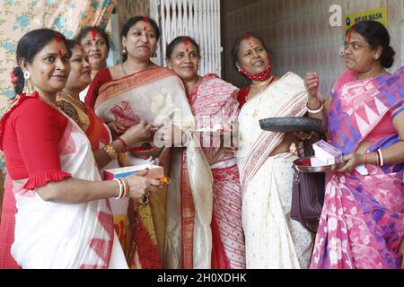 Neu-Delhi, Indien. Oktober 2021. Frauen schmieren sich beim Sindoor Khela am letzten Tag des Durga Puja Festivals in Aaram Bagh Pooja Samiti in Neu-Delhi, am Freitag, den 15. Oktober 2021, Sindoor oder Zinnoberrot auf die Gesichter. Sindur khela und das Eintauchen oder Visarjan der Göttin Durga fanden ohne die übliche Inbrunst aufgrund der Covid-19 Pandemie statt. Die traditionelle sindur-Khela, in der verheiratete Frauen einander mit Zinnoberrot übersäten, war meist auf wenige Anwohner und Organisatoren der Pandalen beschränkt. Foto von Akash Anshuman/ABACAPRESS.COM Quelle: Abaca Press/Alamy Live News Stockfoto