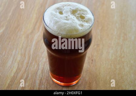 Ein rotes IPA in einem Pint Glas auf dem Tisch Stockfoto