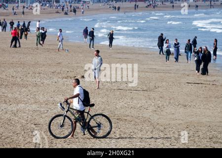 Leute am Strand La Malvarrosa Valencia Spanien Mann schieben Fahrrad Stockfoto