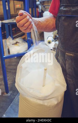 Offener weißer Kunststoffsack mit Granulat in der Sortierlinie Stockfoto