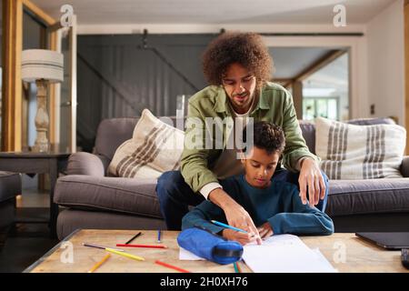 Vater hilft Sohn zu Hause zeichnen Stockfoto