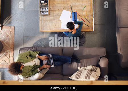 Overhead von Mann mit Laptop und Junge Zeichnung Stockfoto