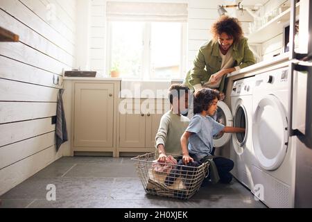 Jungen machen Wäsche mit Vater beobachten Stockfoto