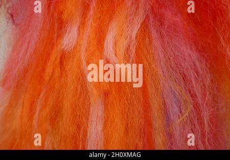 Flauschige wollartige Fäden in den Farben rot, orange, pink, weiß Stockfoto