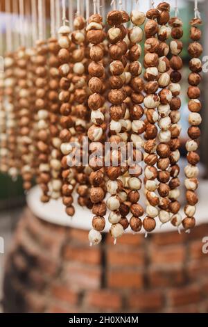 Georgische Süße Churchkhela - eine traditionelle Würstchenform Süßigkeiten durch Eintauchen einer langen Reihe von Nüssen in eine Mischung aus Mehl, Zucker und Badagi - Stockfoto