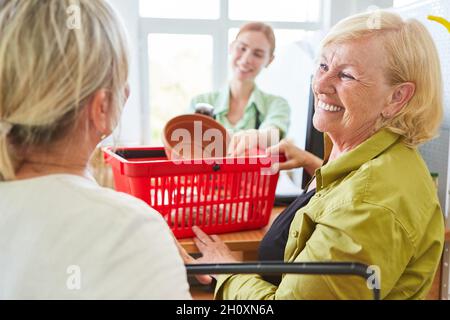 Lächelnder Kunde bei der Bezahlung an der Kasse im Gartencenter oder im Baumarkt Stockfoto