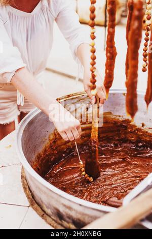 Georgische Süße Churchkhela - eine traditionelle Würstchenform Süßigkeiten durch Eintauchen einer langen Reihe von Nüssen in eine Mischung aus Mehl, Zucker und Badagi - Stockfoto